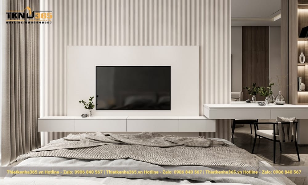 Đối diện giường ngủ là hệ kệ tivi kết hợp với bàn trang điểm màu trắng trang nhã.