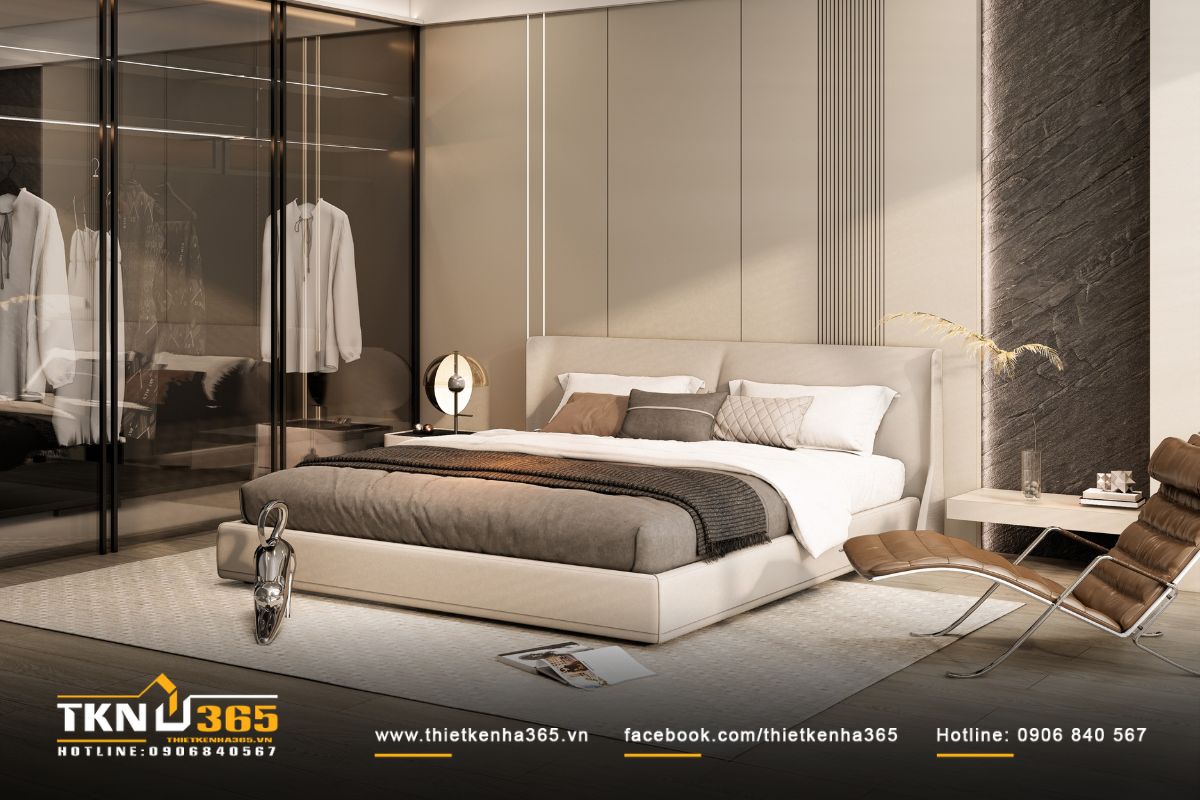 Phòng ngủ master thiết kế tinh tế, giường bọc nỉ màu be và tường đầu giường ốp đá và gỗ cân đối