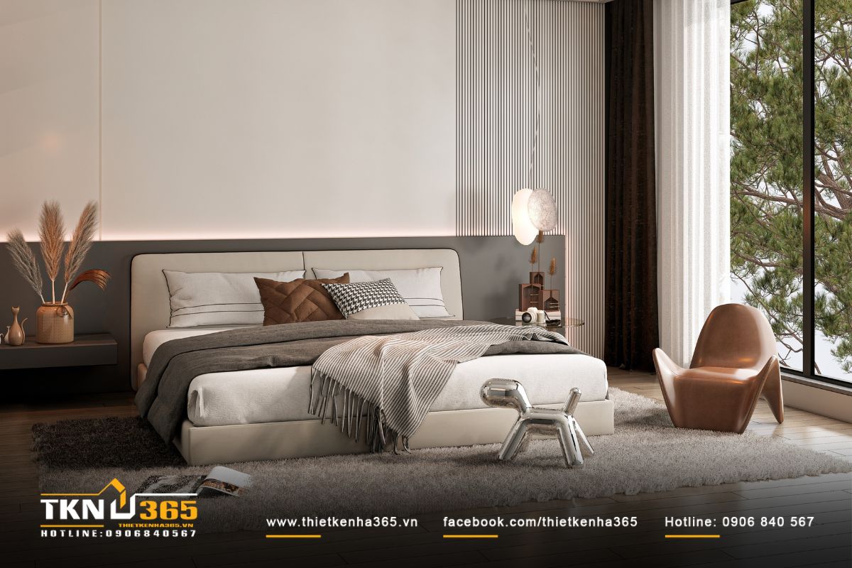 Giường bọc nỉ mềm kết hợp ghế lounge da nâu bên cửa sổ, cho phép ánh sáng tự nhiên tràn vào qua lớp rèm voan nhẹ