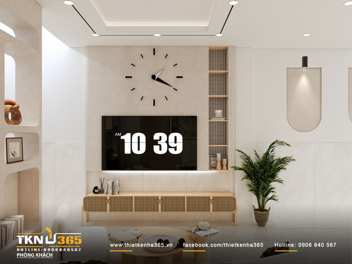 Bức tường tivi tối giản với gam màu kem, đồng hồ treo tường mảnh và kệ mở kịch trần tạo điểm nhìn gọn và sang