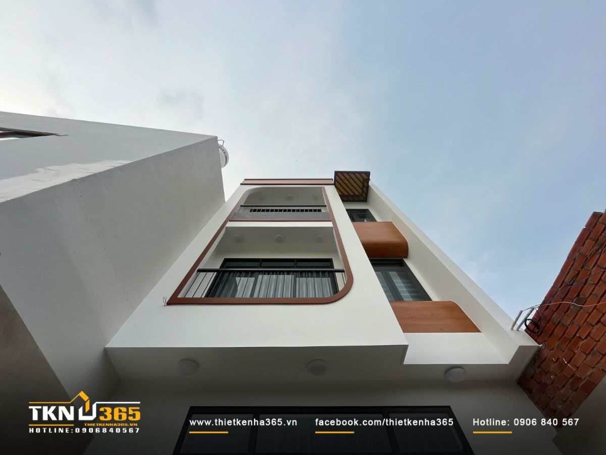 Ban công uốn nhẹ và chi tiết lam che nắng giúp mặt tiền thanh thoát, đồng thời cải thiện ánh sáng và thông gió cho toàn bộ ngôi nhà