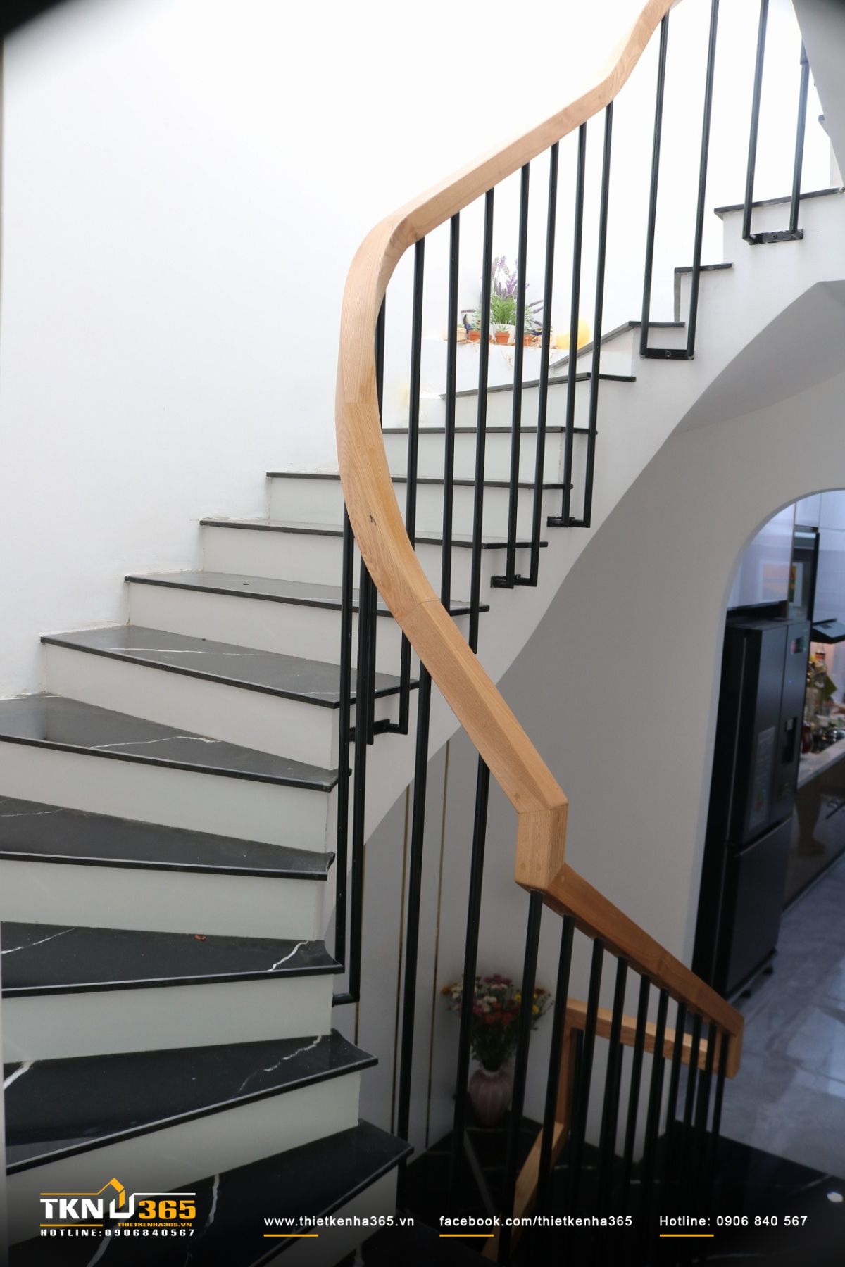 Lan can cầu thang uốn cong mềm mại, làm dịu nhịp di chuyển trong không gian nhà phố 3 tầng