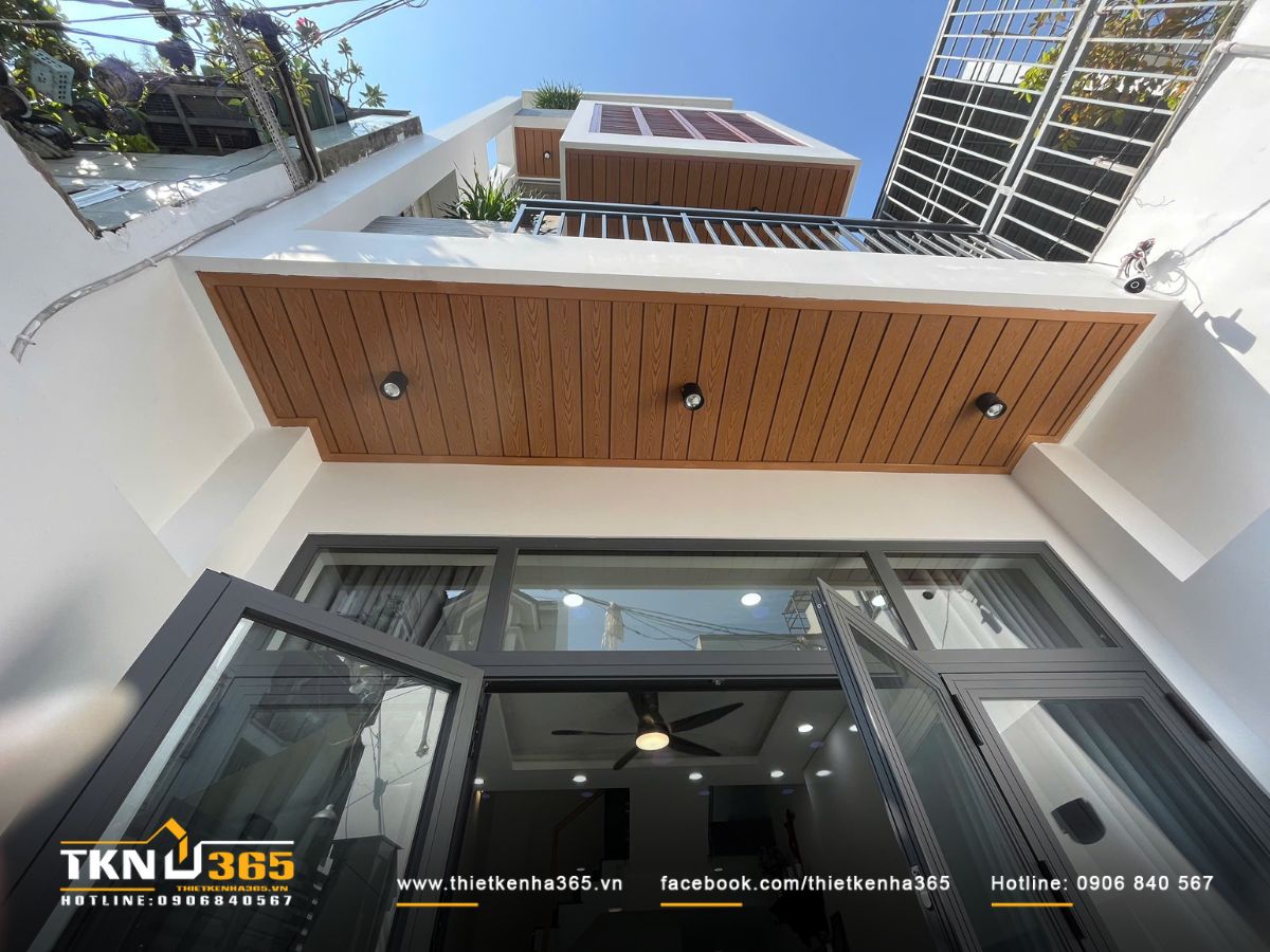 Nhà phố 3 tầng thiết kế hiện đại, trần ốp gỗ ấm và hệ cửa kính lớn giúp không gian luôn thoáng sáng