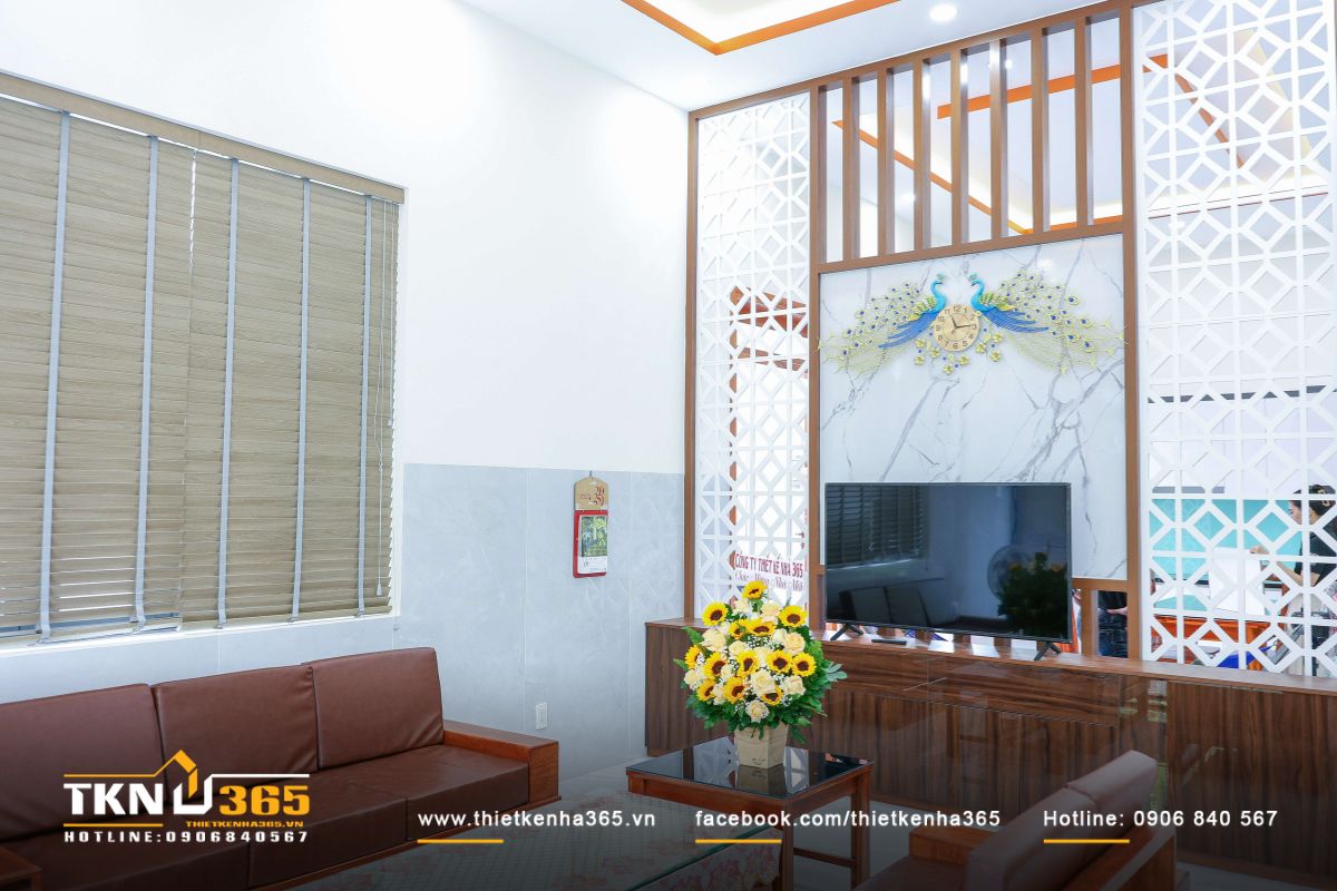 Bộ sofa bằng gỗ nguyên khối đặt ở vị trí trung tâm là điểm nhấn của thiết kế phòng khách T’S House
