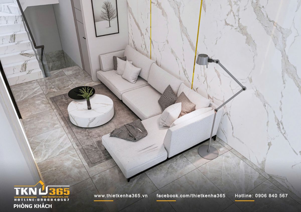 Bộ sofa chữ L bố trí sát tường giúp tối ưu diện tích, kết hợp bàn trà tròn mặt đá và thảm trung tính, tạo khu tiếp khách gọn gàng, êm ái và dễ kết nối