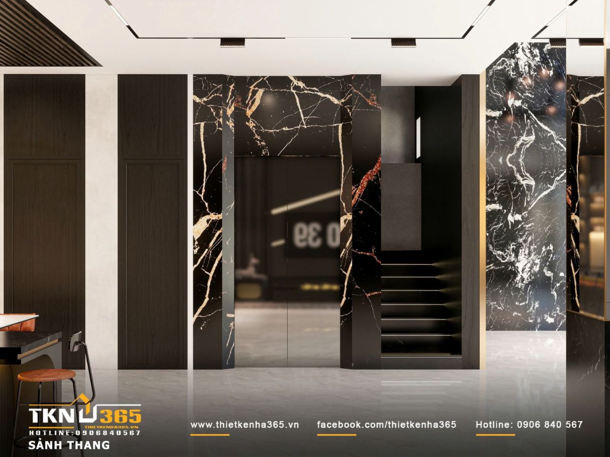 Sảnh thang nhấn bằng mảng đá vân kết hợp ánh sáng âm trần và đèn hắt, tạo chiều sâu thị giác và dẫn dắt không gian một cách rõ ràng