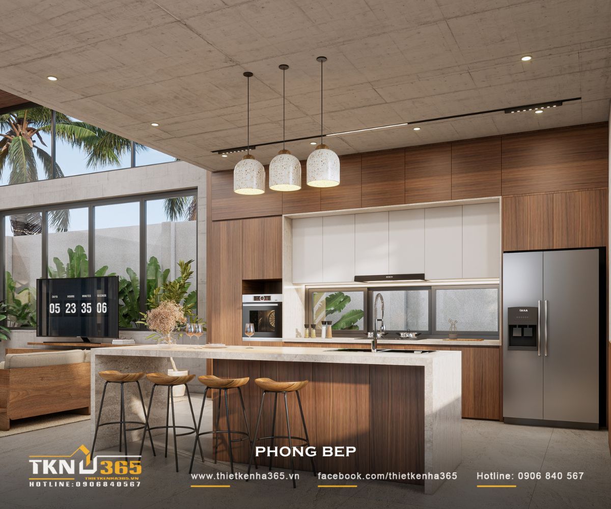 Hệ cửa sổ chạy dọc bàn bếp bổ sung ánh sáng cho khu vực thao tác, trong khi đảo bếp hướng ra sân vườn tạo tầm nhìn thoáng khi sử dụng