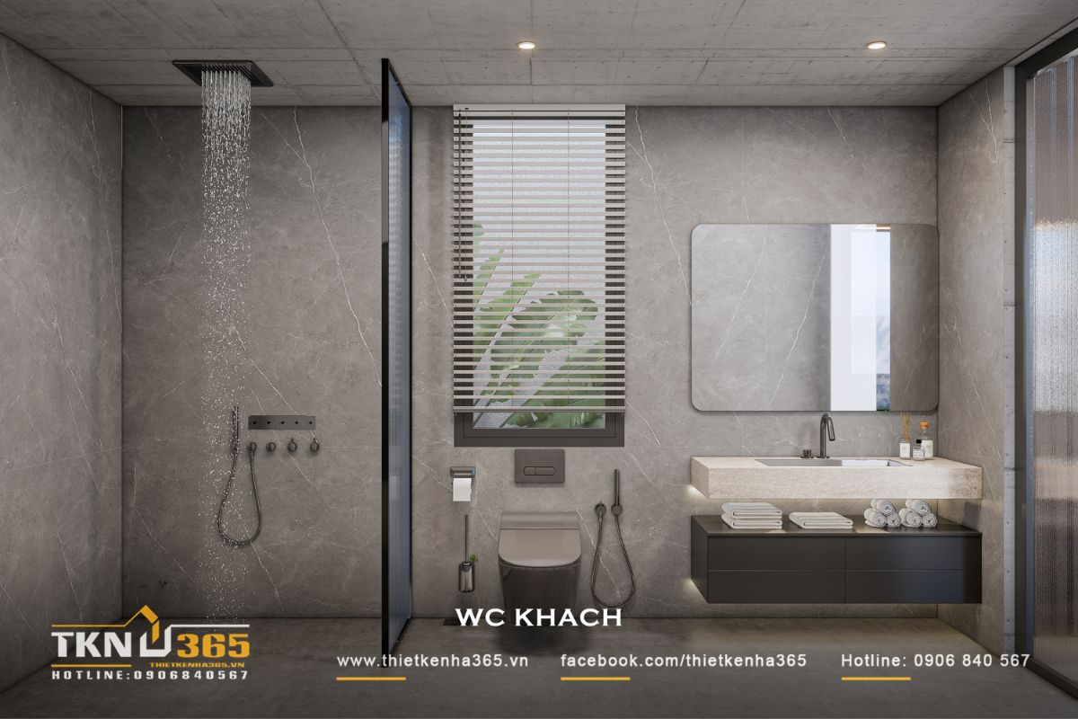 WC khách tiếp tục sử dụng vật liệu xám cùng thiết bị tối màu, tạo sự thống nhất với WC master và ngôn ngữ nội thất chung của ngôi nhà