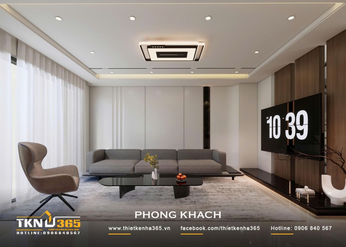 Sofa xám, bàn trà đen và thảm lớn tạo độ tương phản nhẹ trên nền nội thất trung tính